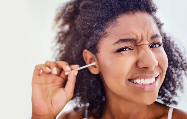 Jeune femme qui se lave les oreilles avec un coton-tige