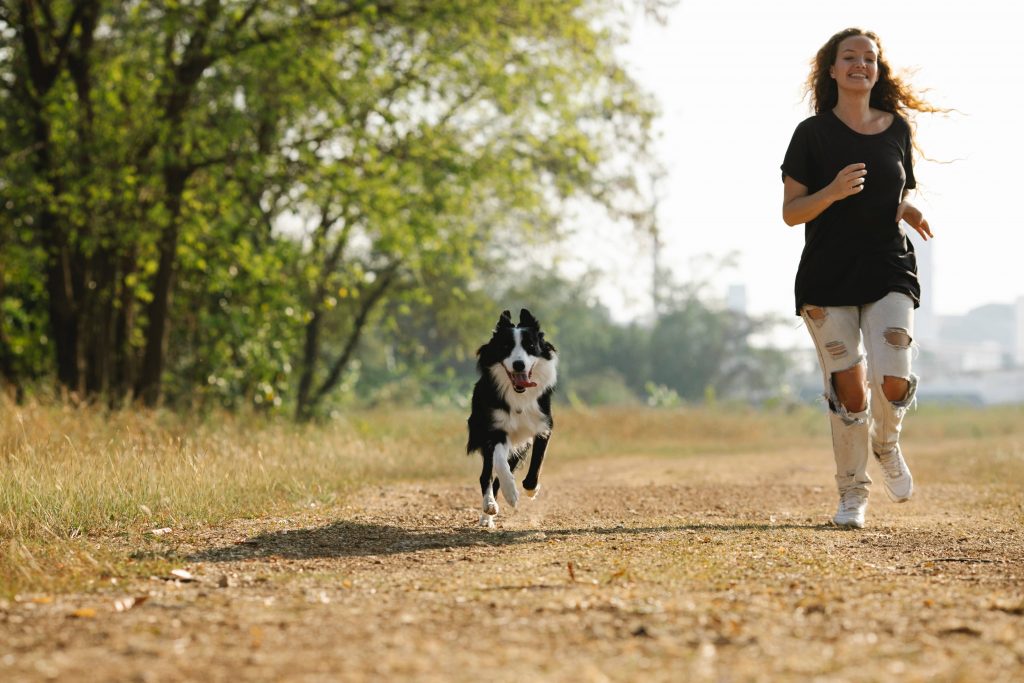 Chien qui court avec sa maîtresse